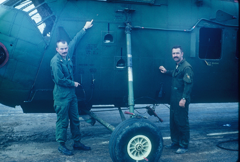 Captain Brian West and Major Tom Hill pointing out some bullet holes to their aircraft that killed the Crew Chief, Cpl. John Wiseman of St. Louis